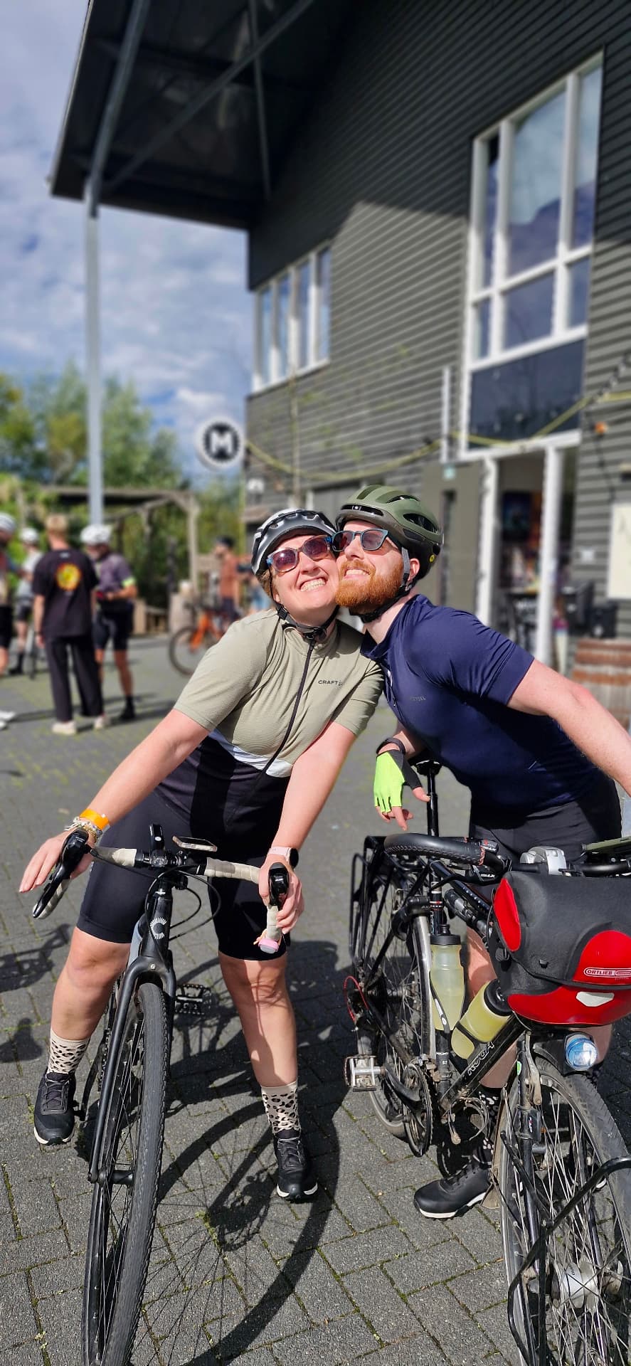 Twee deelnemers met hun fietsen voor de brouwerij tijdens Brouwerijders